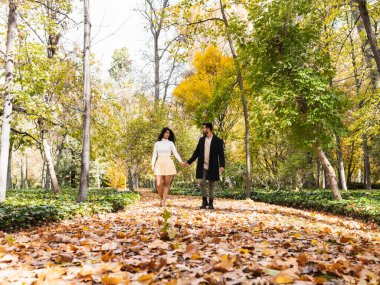 Parkta yürüyen genç aşıklar