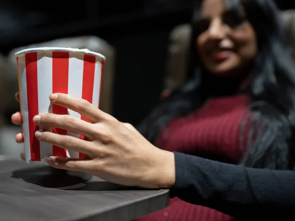 woman eating popcorn at the cinema