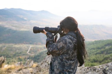 Kadın telefoto lensleriyle fotoğraf çekiyor.