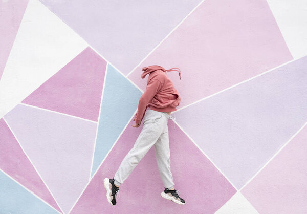 woman jumping on a pink background faceless person