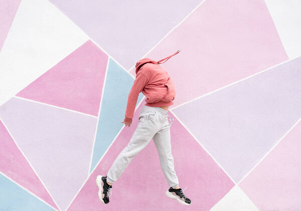 woman jumping on a pink background faceless person