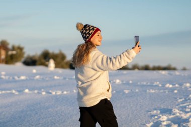 Karda cep telefonu olan bir kadın.