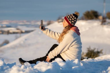 Karda cep telefonu olan bir kadın.