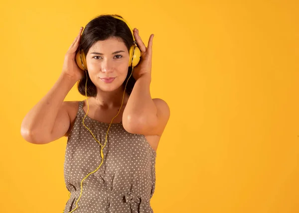 用黄色耳机听音乐的女人 — 图库照片