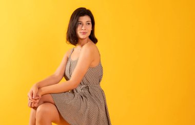 Güzel esmer kadın, günlük kıyafetler, mutlu, sarı arka planda gülümseyen, kopyalama alanı