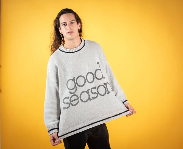 man in sweater and long hair with letters that says: good season. on yellow background