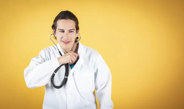 Steteskopu Olan Yakışıklı Bir Doktor Gülümseyen Şakalar Sarı Arka Plan — Stok fotoğraf