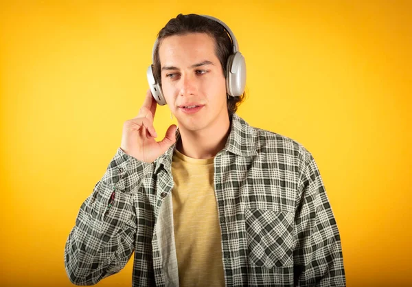Ung Kille Lyssnar Musik Hörlurar Glad Leende Orange Bakgrund — Stockfoto