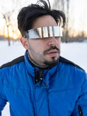 Telefonuyla karda güneş gözlüklü yakışıklı bir adam.