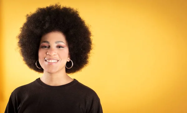 mixed afro hair woman smiling happy, yellow background copy space