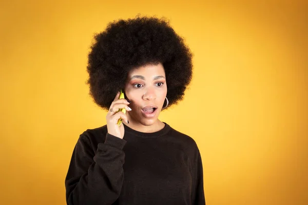 Una Mujer Negra Alegre Con Una Sonrisa Juguetona Escucha Una — Foto de Stock