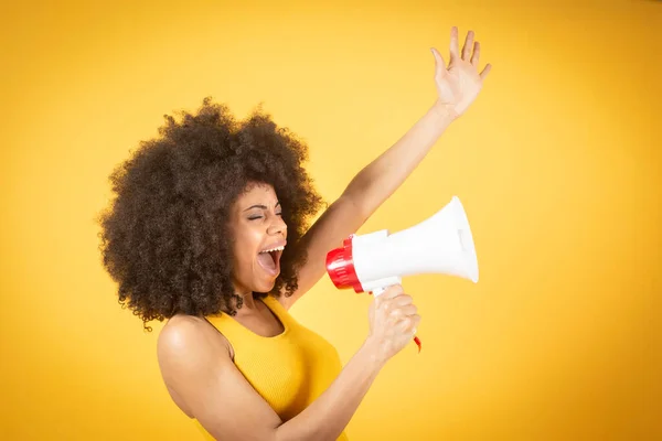 Kıvırcık saçlarıyla gülümseyen ve kırmızı megafonla bağıran güzel Afro-Amerikan kadın..
