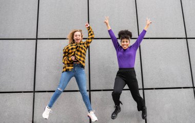 İki çok ırklı genç kadın şehirde eğleniyor.