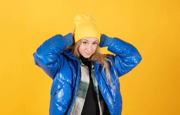 blonde woman with blue casual clothes and yellow hat