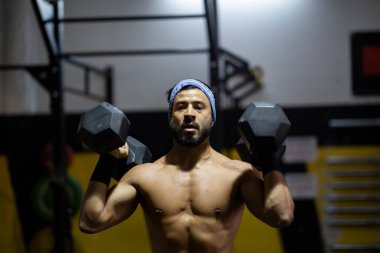 Spor salonunda ağırlık çalışan Latin bir adam.