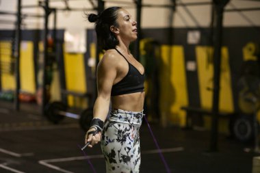 Kadın spor salonunda ağırlık kaldırıyor.