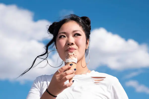 Asian woman eating ice cream on the street