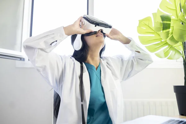 female doctor, with laptop and virtual reality glasses