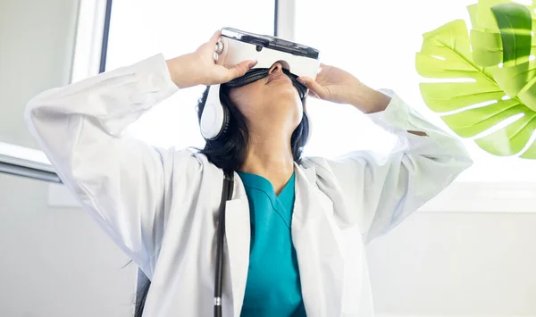 pretty female doctor using virtual reality glasses in consultation