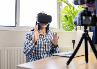 Güzel kadın evde sanal gerçeklik gözlüğü takıyor.