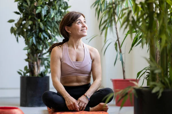 pretty older woman smiling while practicing yoga