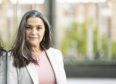 Olgun, gümüş saçlı, şehirde iş portresi