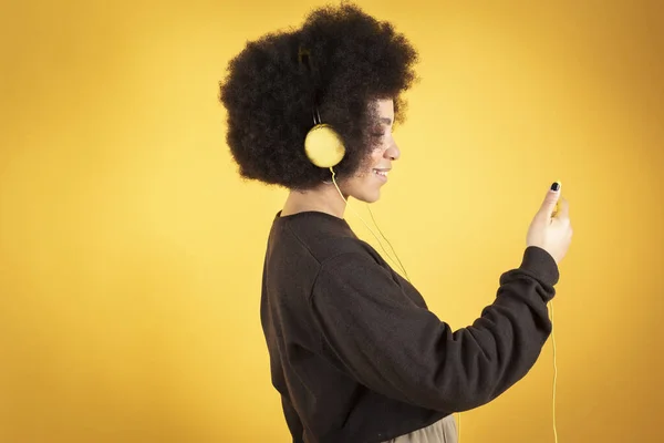 Mujer Afro Bonita Escuchando Música Con Auriculares Teléfono Inteligente Fondo —  Fotos de Stock