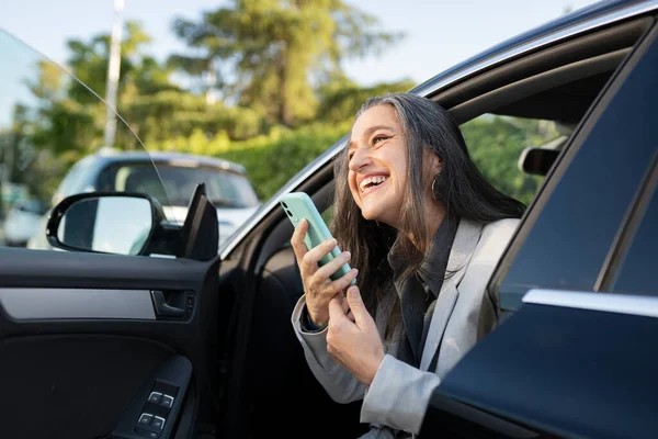 woman sending a voice message with the cell phone in the car