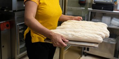 Fırıncı kadın elleri ekmek pişiriyor.