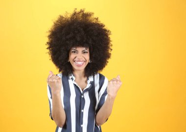 Kadın sevinçten çığlık atıyor ve sarı duvara gülüyor.