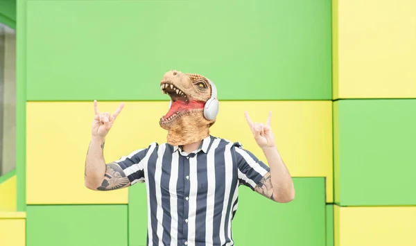 Man Met Een Dinosaurus Masker Luistert Naar Muziek Met Koptelefoon — Stockfoto
