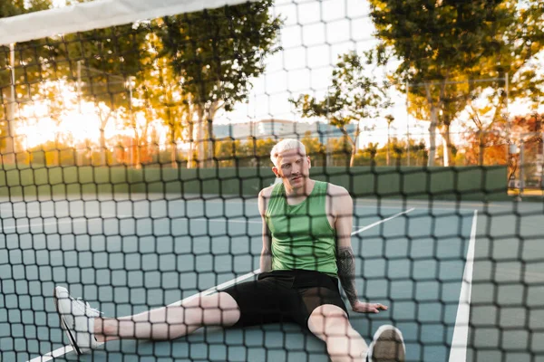 Młody Mężczyzna Sportowiec Blond Albinos Siedzi Korcie Tenisowym Rozprostowuje Nogi — Zdjęcie stockowe