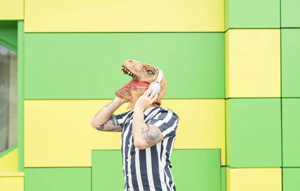 Man Dinosaur Mask Listening Music Green Background — Foto de Stock