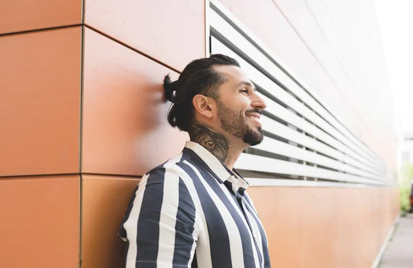 handsome man on a wall in the street smiling