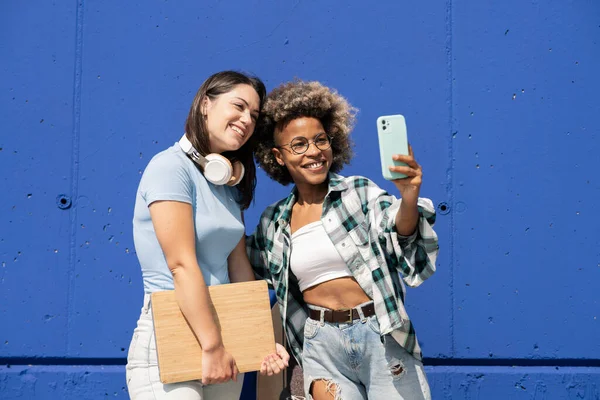 Dois Amigos Multiétnicos Tirando Fotos Com Telefones Celulares Com Fones — Fotografia de Stock