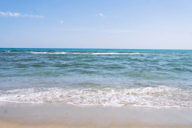Turkuaz suyu ve mavi gökyüzü olan güzel bir sahil, yaz konsepti.