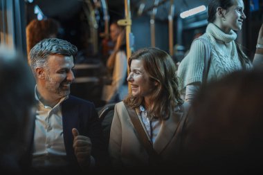 Kadın ve erkek, gece vakti kalabalık bir otobüste gülüşür ve sohbet eder. İçsel ışıklarla sıcak bir şekilde aydınlatılır. Bir akşam arasında rahatlar ve birbirlerine bağlanırlar.