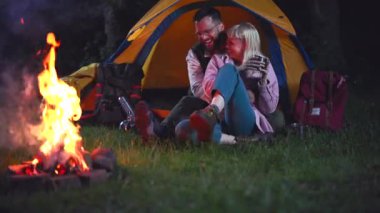 Sevecen genç bir çift romantik bir akşamın keyfini çıkarıyorlar. Sıcak bir şenlik ateşinin başında kamp yaparken sarılıp sohbet ediyorlar. Gece gökyüzünün altında çadırlarının önünde birlikte oturuyorlar.