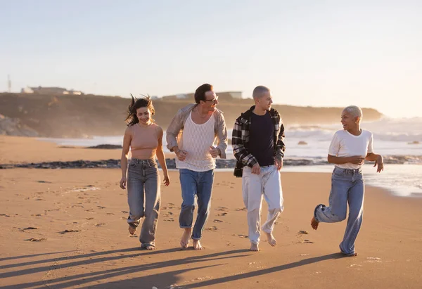 Çeşitli yetişkin arkadaş grupları birlikte aktif zaman geçiriyorlar. Altın saat boyunca kumsalda çıplak ayakla koşuyorlar. Neşe ve özgürlüğü yansıtıyorlar.