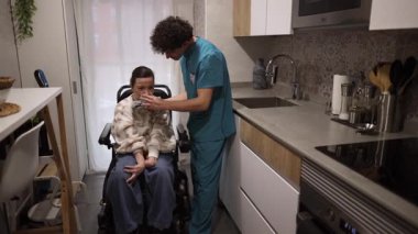 Erkek hemşire, tekerlekli sandalyedeki engelli bir kadına evde sanal gerçeklikte yardım ediyor. Gelişmiş tıp teknolojisi hastalara eğlence ve tedavi desteği sağlıyor