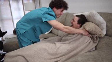 Erkek hemşire, tekerlekli sandalyedeki engelli bir kadına evde sanal gerçeklikte yardım ediyor. Gelişmiş tıp teknolojisi hastalara eğlence ve tedavi desteği sağlıyor