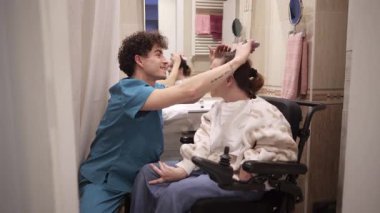 Erkek hemşire, tekerlekli sandalyedeki engelli bir kadına evde sanal gerçeklikte yardım ediyor. Gelişmiş tıp teknolojisi hastalara eğlence ve tedavi desteği sağlıyor