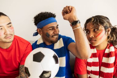 Çeşitli yetişkin arkadaş grupları evde futbol maçı izlerken farklı duygular ifade ediyorlar. Bir kişi bir hedefi kutlarken diğeri hayal kırıklığını gösteriyor.