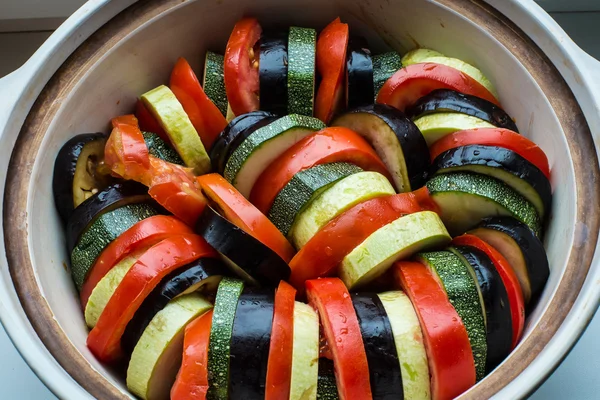 Färgglad grönsak skivor i en lerkruka Stockfoto