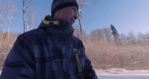 Alegre descenso desde la montaña cubierta de nieve en una tabla de snowboard . — Vídeo de stock