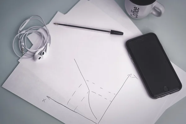 Bolígrafo para tomar notas en papel junto a su smartphone — Foto de Stock