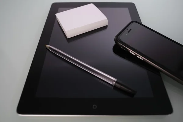 Nahaufnahme von Handy und Tablet-Computer auf einem verspiegelten Tisch — Stockfoto