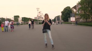 Rusya, Moskova - 23 Temmuz 2016: iPhone Fotoğraflar parkta VDKNh aracılığıyla leafing ile güzel sarışın