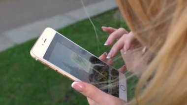 Rusya, Moskova - 23 Temmuz 2016: iPhone Fotoğraflar parkta VDKNh aracılığıyla leafing ile güzel sarışın