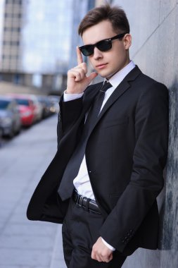 Duvara yakın duran ve yüz noktalarında dokunmadan işadamı